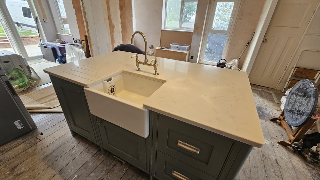 AN image of a worktop fitted on a kitchen island with a sink in the middle.